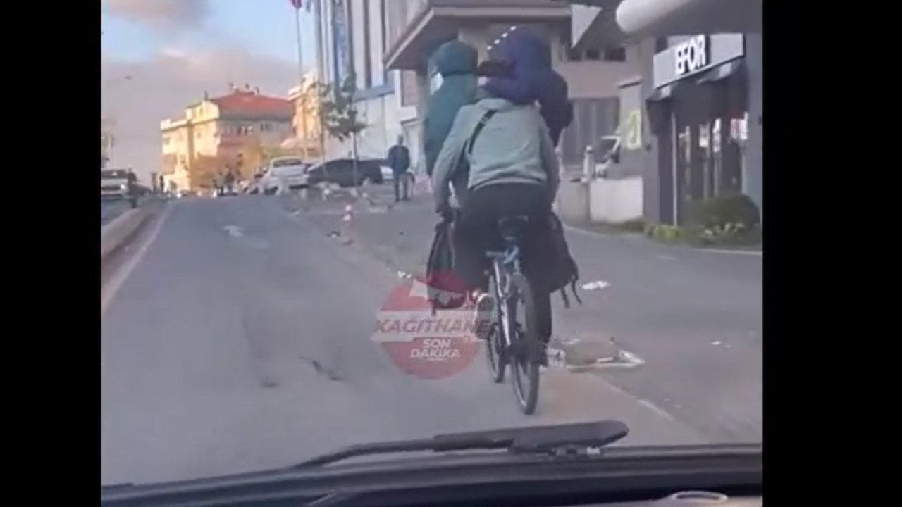 Kucağında iki çocukla bisiklet sürdü!