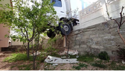 Freni boşalan kamyon, çarptığı duvarda asılı kaldı